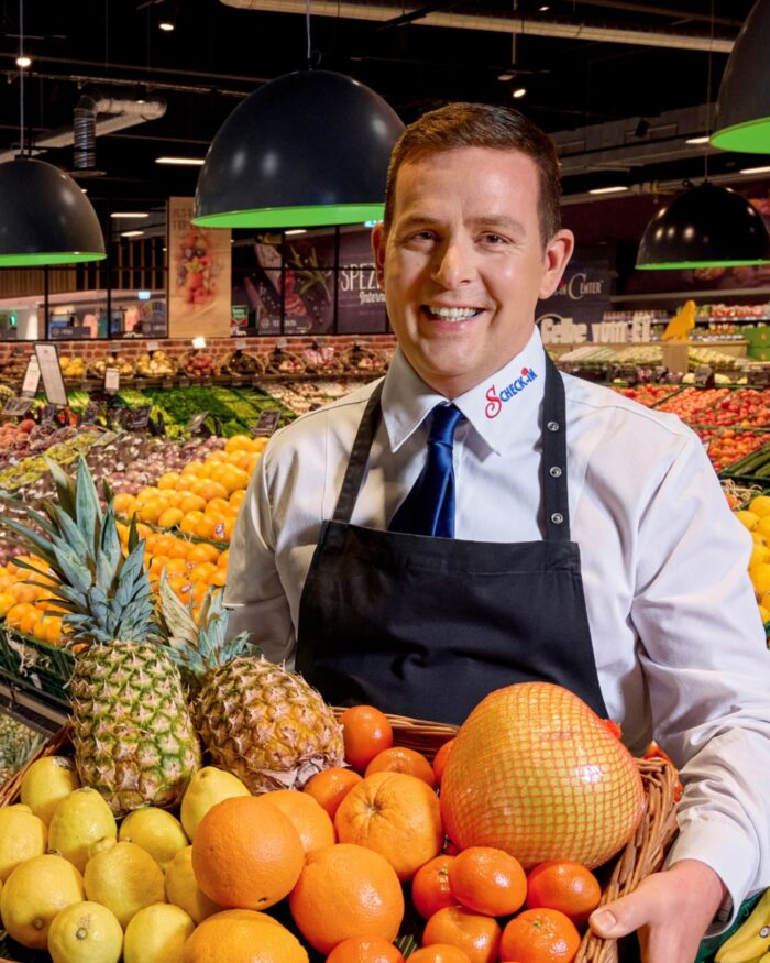 Mensch vor Obst und Gemüseabteilung