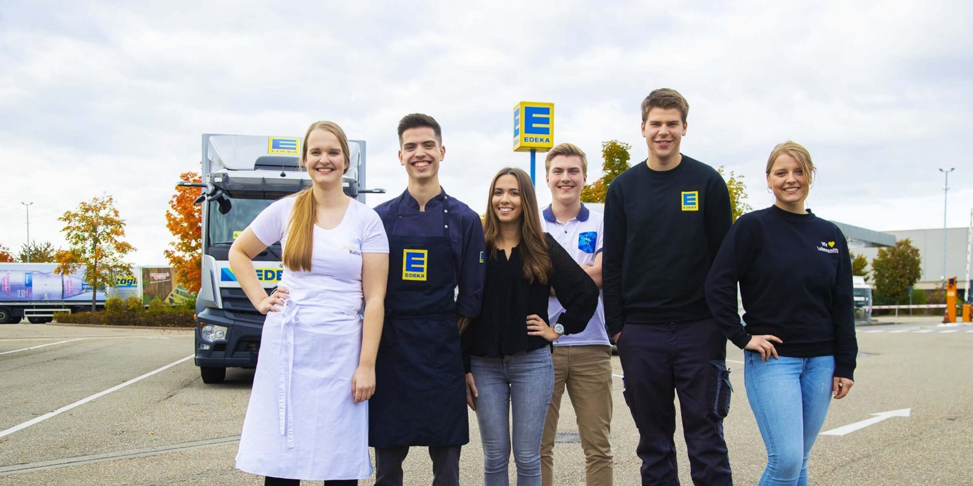 Azubis und dual Studierende von EDEKA Südwest stehen aufgereiht im EDEKA-Arbeitsoutfit